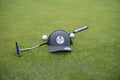 A Charcoal and Black OG hat by Fore Over Par shown on a golf green with a putter and two golf balls behind it.