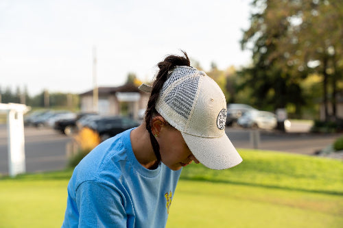 Female wearing a Cream Pony Tail Club Hat by Fore Over Par on Golf course