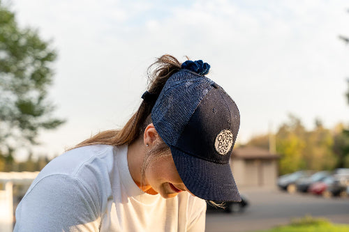 Female wearing a Dark Blue Pony Tail Club Hat by Fore Over Par while on a golf course