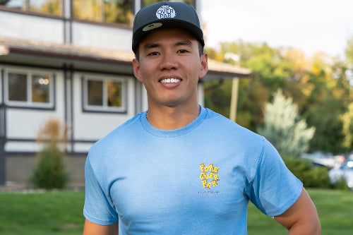 5'9" Male on a golf course wearing a dark grey 19th Hole Rope Hat and light blue Fringe Society tee shirt by Fore Over Par