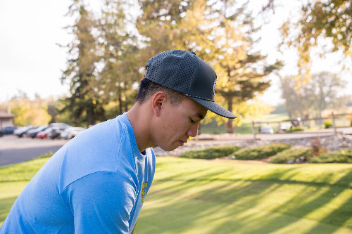 Male wearing a 19th Hole Rope hat by Fore Over Par on a golf course