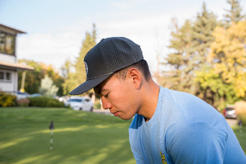 Male wearing a 19th Hole Rope Hat by Fore Over Par on a golf course