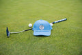 Light blue 19th Hole Rope Hat by Fore Over Par shown on a green with a putter and two golf balls behind it. 