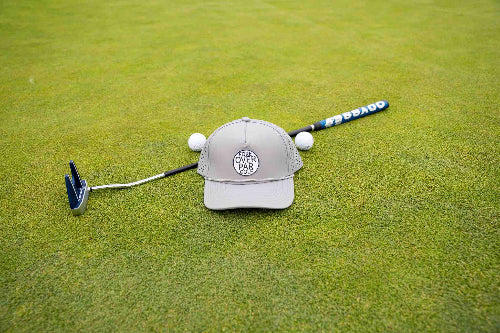 Grey 19th Hole Rope hat by Fore Over Par shown on golf green with putter and two golf balls behind it. 