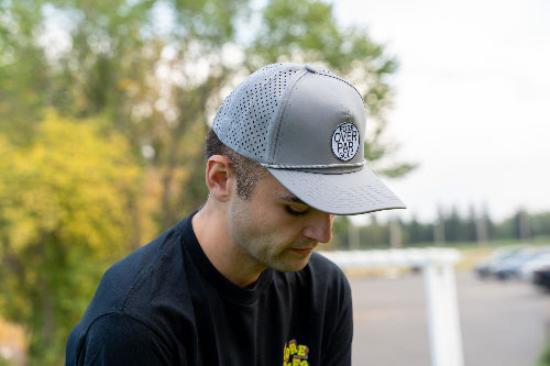 Male wearing a grey 19th Hole Rope hat by Fore Over Par on a golf course