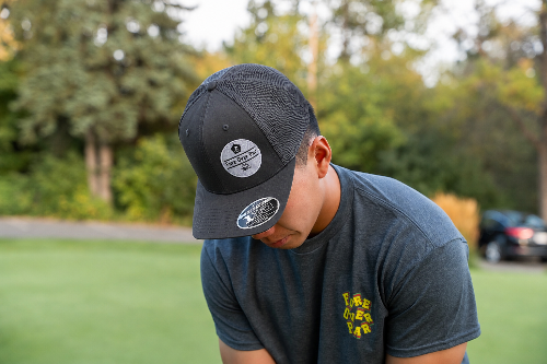 A 5'10" man on a golf course wearing a grey Apex hat by Fore Over Par