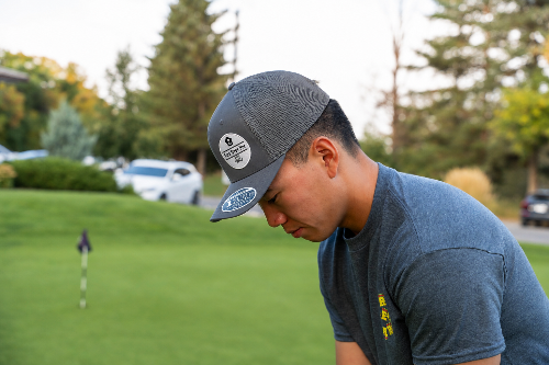 A 5'10" man one a golf course wearing a grey Apex at by Fore Over Par