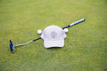 Grey Pony Tail Club hat by Fore Over Par shown on a golf green with a putter and two golf balls shown behind it