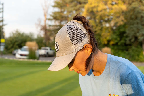 Female wearing a grey Pony Tail Club hat by Fore Over Par on a golf course. 