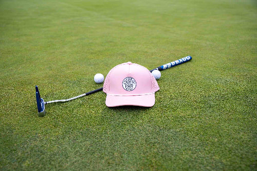 Pink 19th Hole Rope Hat by Fore Over Par shown on a green with a putter and two golf balls behind it