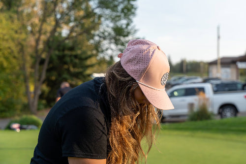Woman wearing a pink 19th Hole Rope Hat by Fore Over Par on a golf course