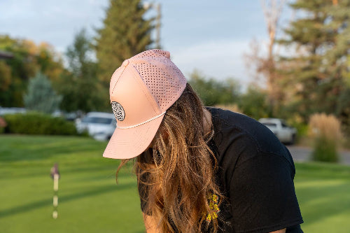 Woman wearing a pink 19th Hole Rope Hat by Fore Over Par on a golf course