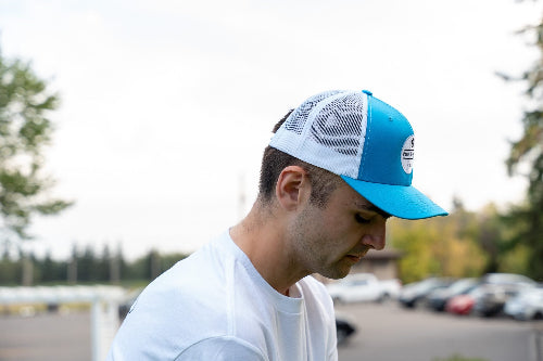 Man wearing a turquoise & white OG Hat by Fore Over Par while on a golf course.