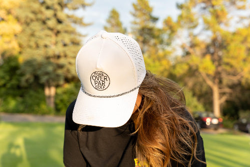 Woman wearing a white 19th Hole Rope Hat by Fore Over Par while on a golf course