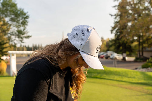 Woman wearing a 19th Hole Rope hat by Fore Over Par while on golf course