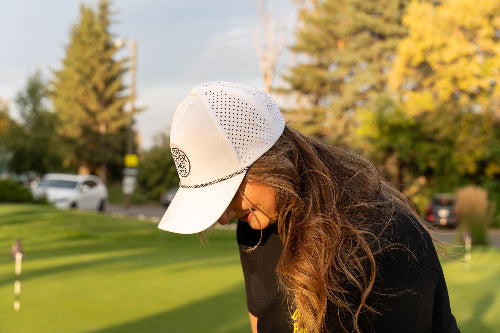 Woman wearing a white 19th Hole Rope Hat by Fore Over Par while on golf course